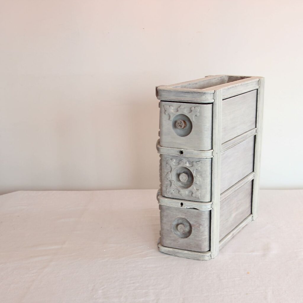 stack of 3 vintage sewing drawers in a frame