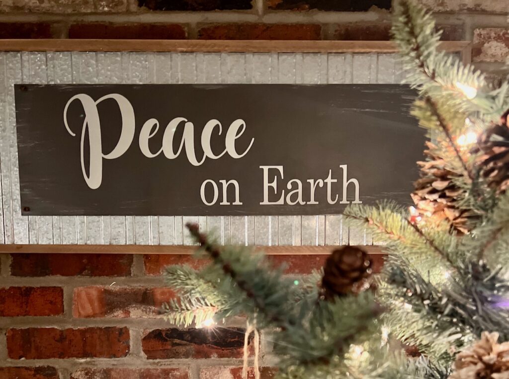 Closeup of a made over thrifted art into a Christmas sign that reads "Peace on Earth"