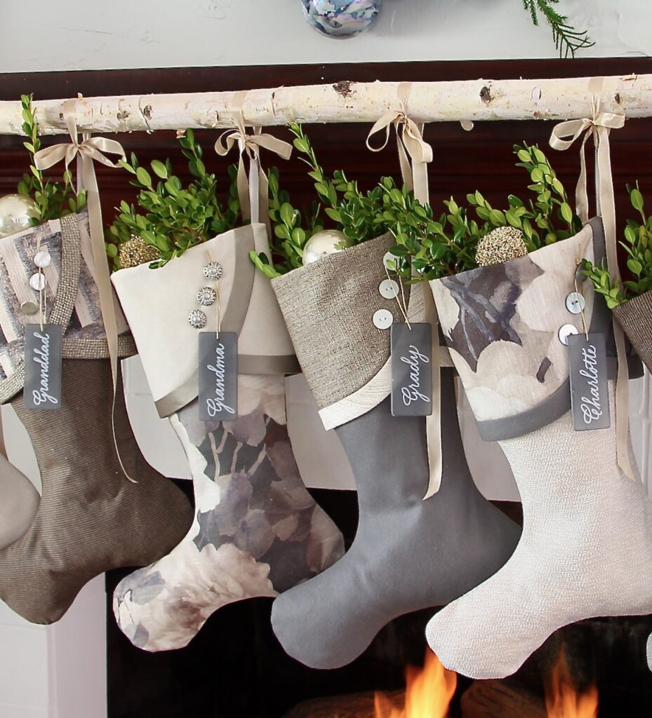 stockings hanging tied to a birch branch rod with long tailed bows of minimalistic ribbon