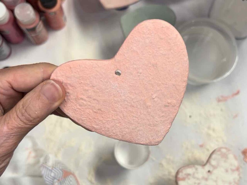 woman's fingers holding the finished clay heart