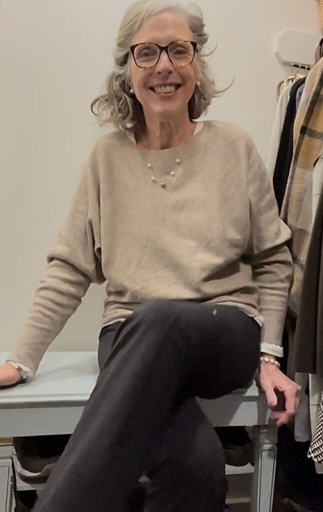 smiling woman sitting on shoe bench in closet