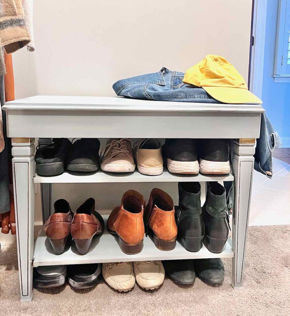 finished Closet bench in a closet with shoes and boots on shelves and a jean jacket and ball cap on top