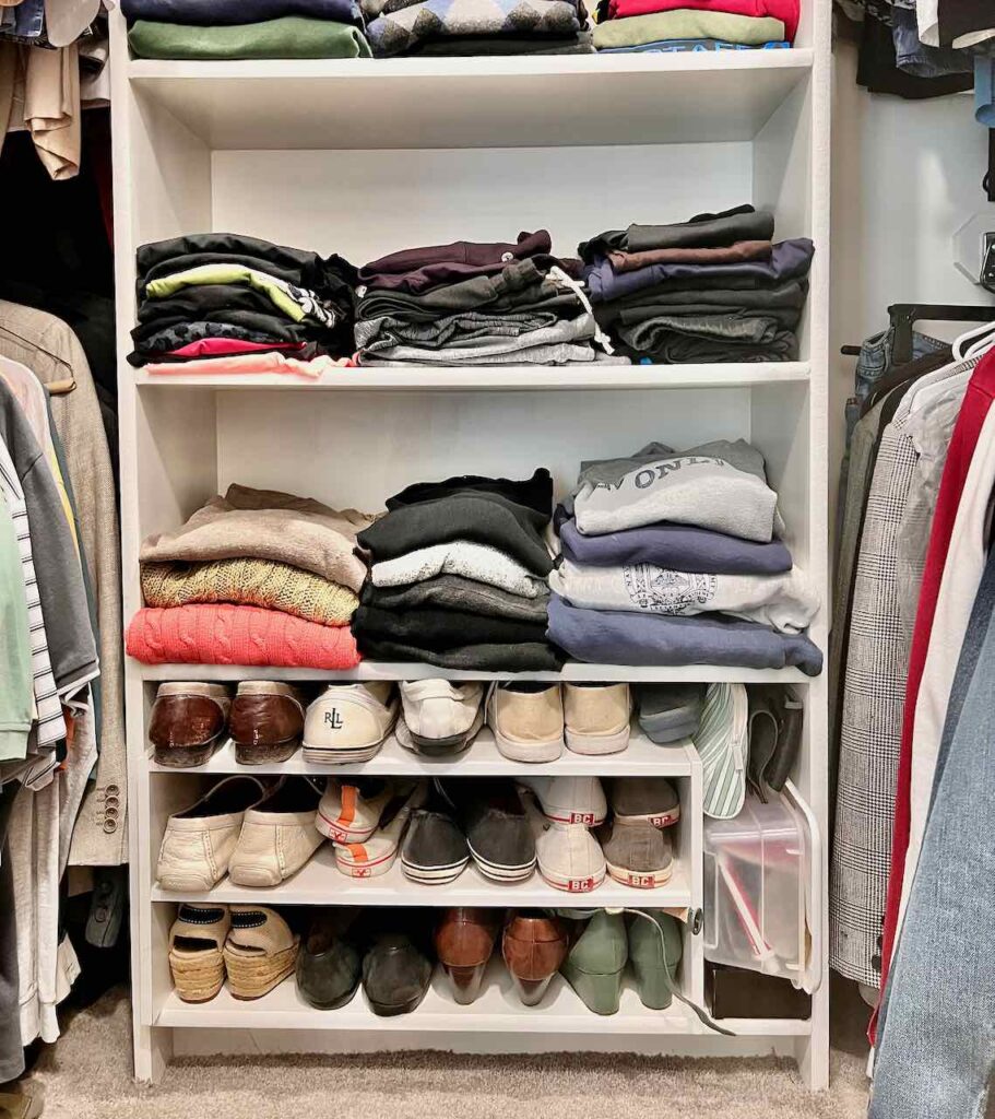 view of built-in shelves inside a walk-in closet with the bottom shelf filled with a shoe rack and sweaters folded above