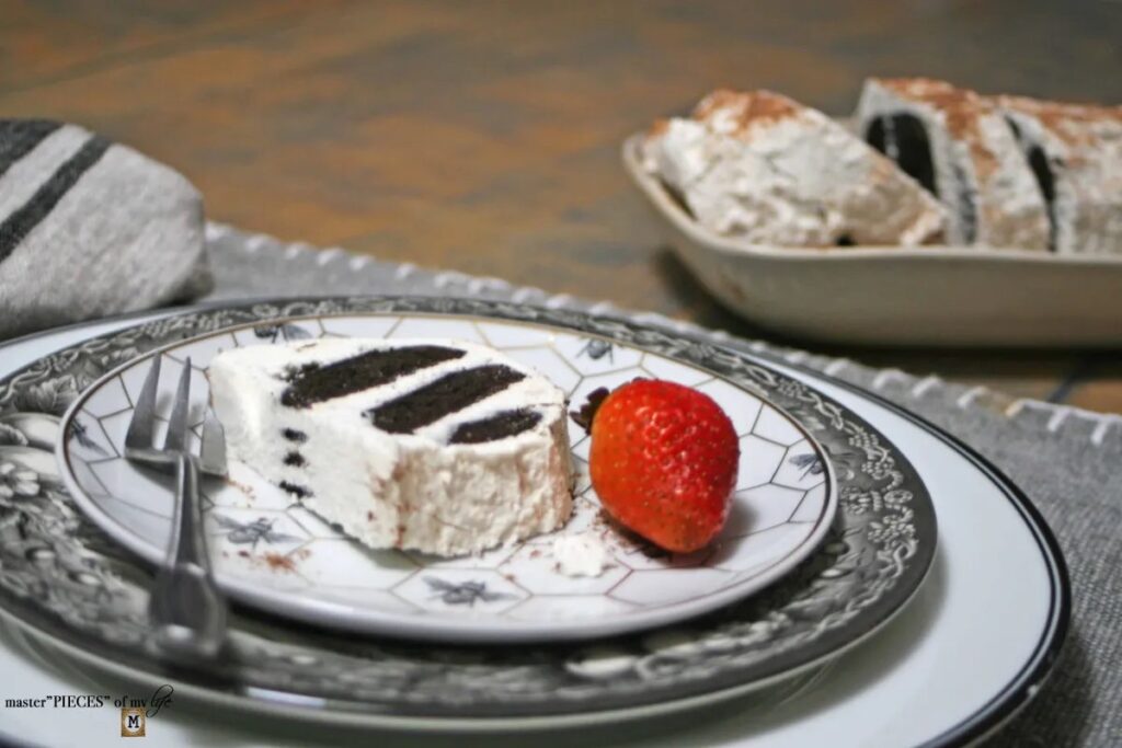 slice of icebox chocolate cake on a plate with the remainder in the background