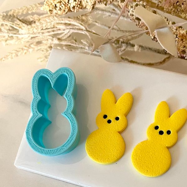 Clay Cutter shaped like a bunny next to two bunnies made with the cutter