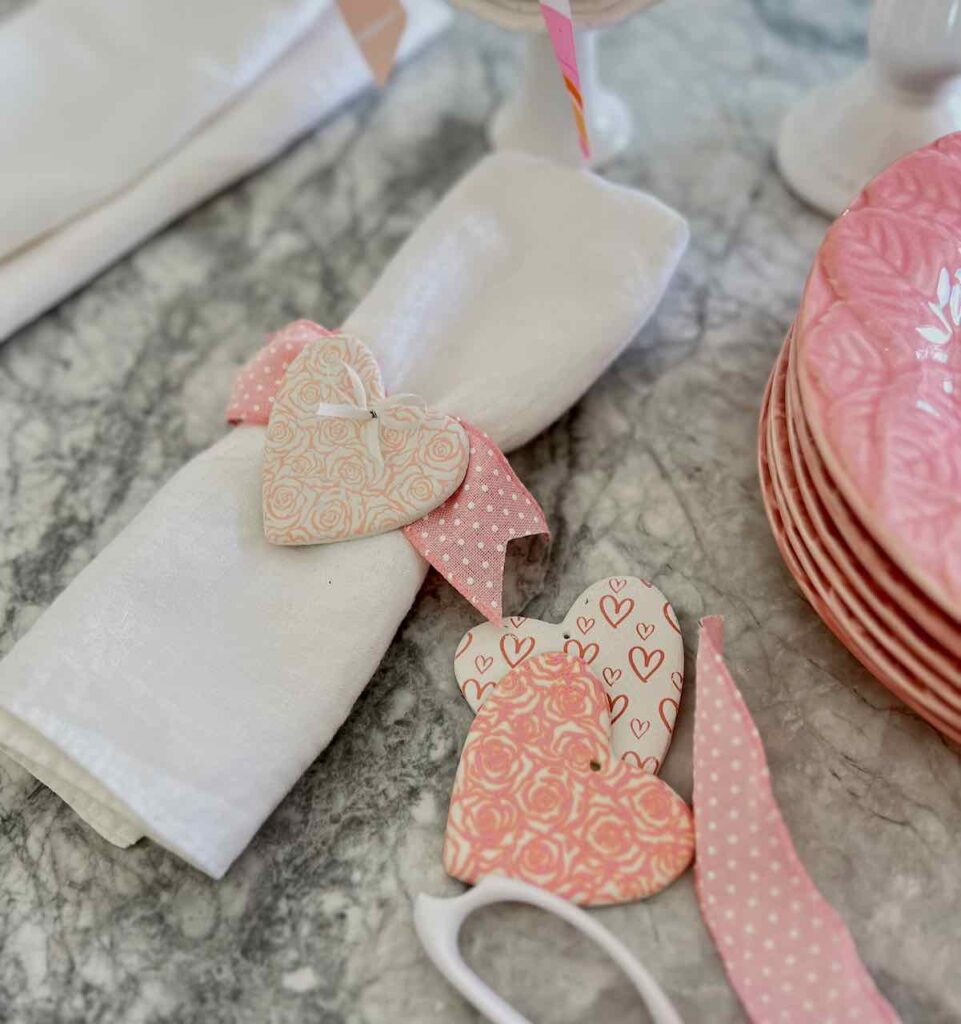 screen-printed hearts are being made into napkin rings with ribbon
