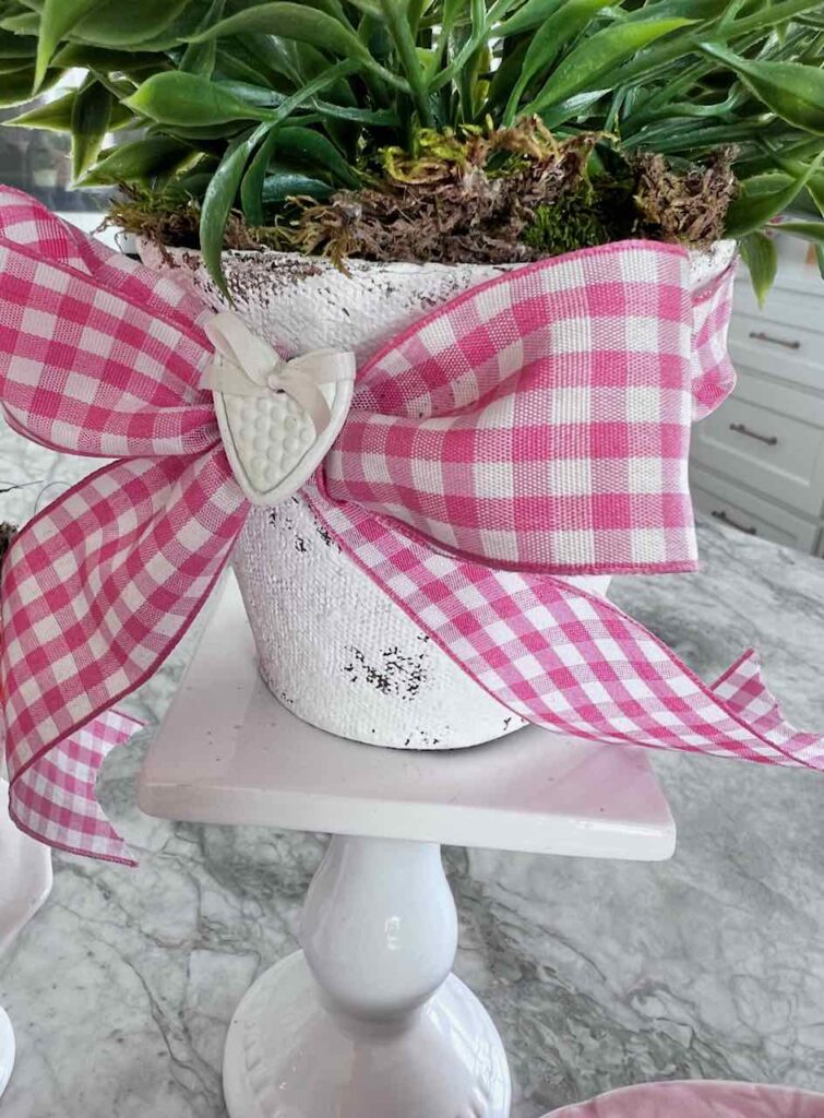 closeup of small textured heart tied onto the bow on a flower pot