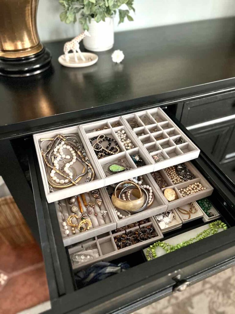 Dresser drawer fully extended open showing jewelry drawer organizer with three layers of velvet jewelry trays 