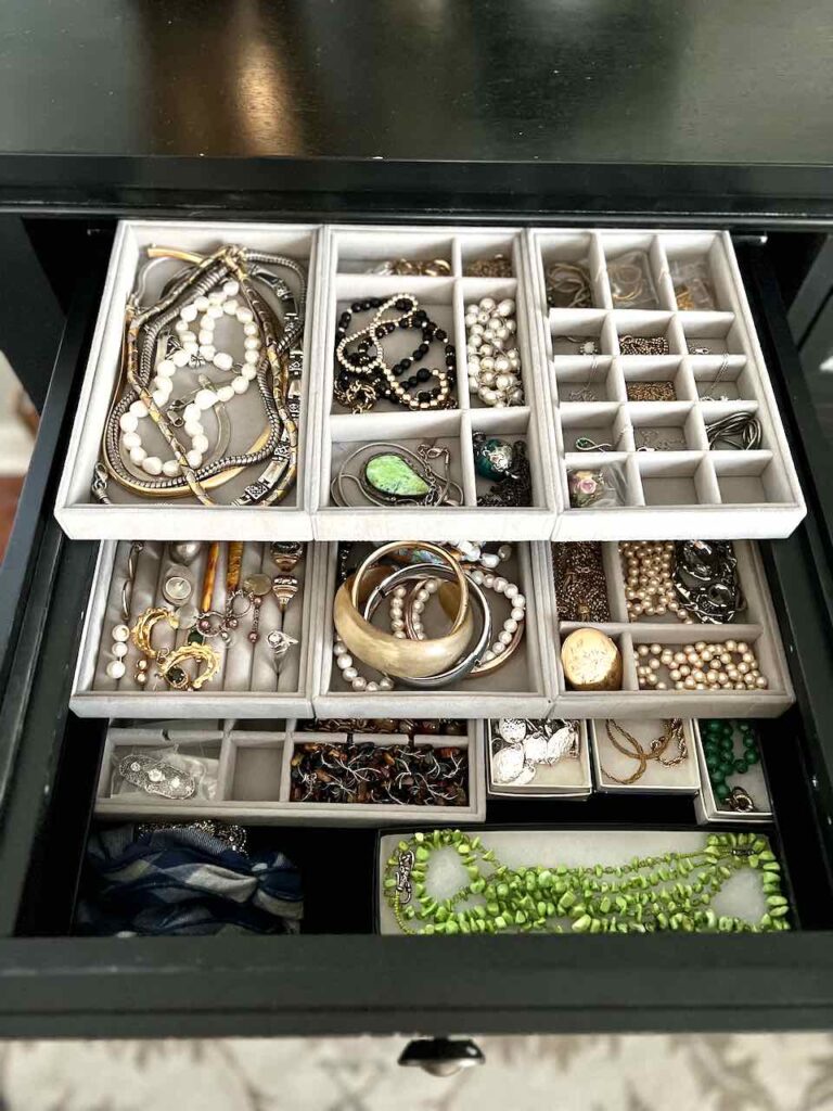 three layers of velvet jewelry trays filled will jewelry neatly arranged in a drawer