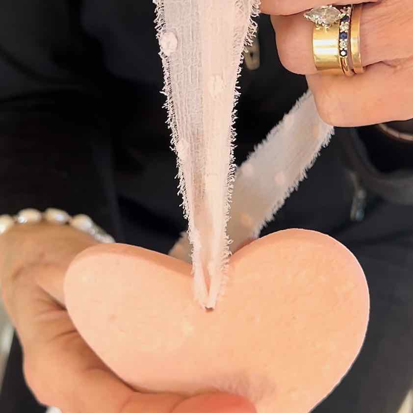 The finished frayed chiffon ribbon is shown threaded through a clay heart