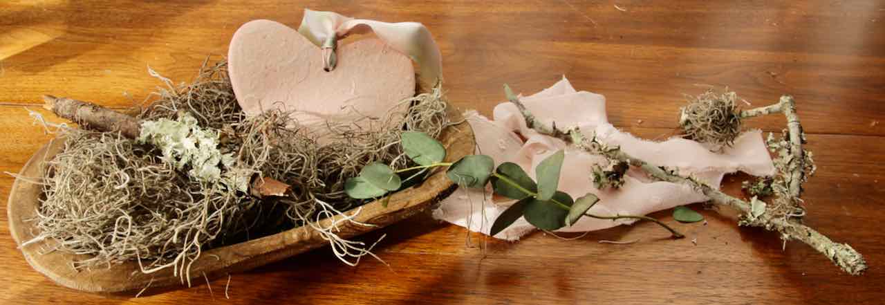 wise closeup image of finished heart propped in a dough bowl with moss and lichen