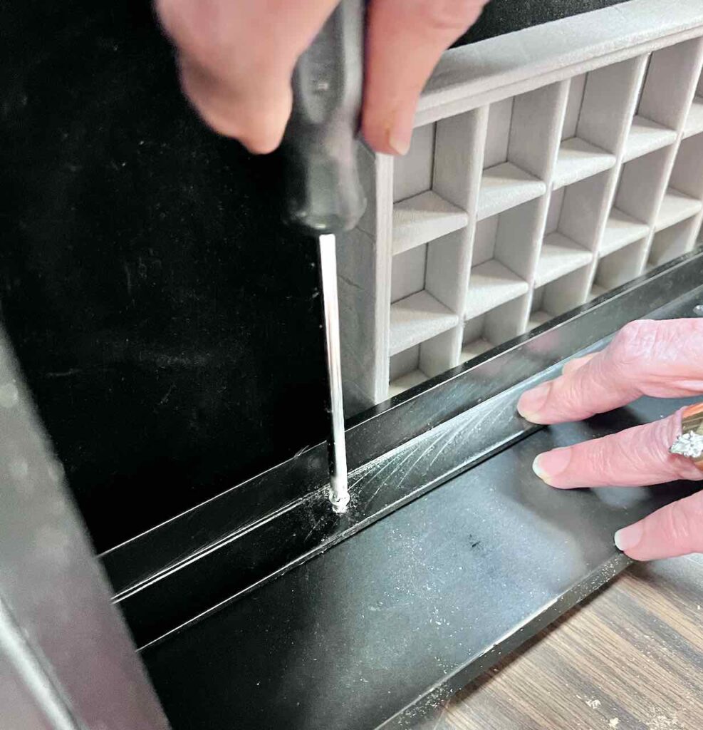 woman's hand using screwdriver to attach rail to drawer