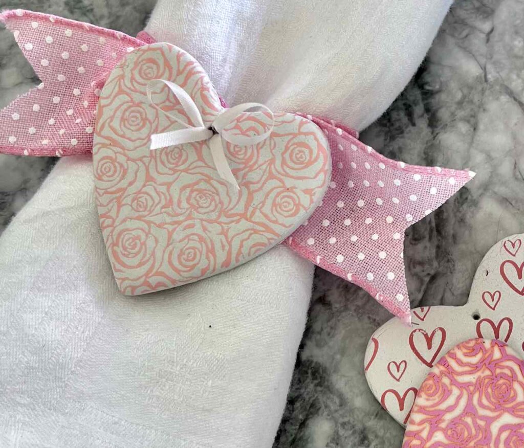 closeup of napkin ring made with a silk screened clay heart and ribbon