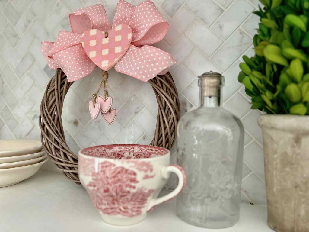 small wreath on kitchen open shelving with bow and clay hearts