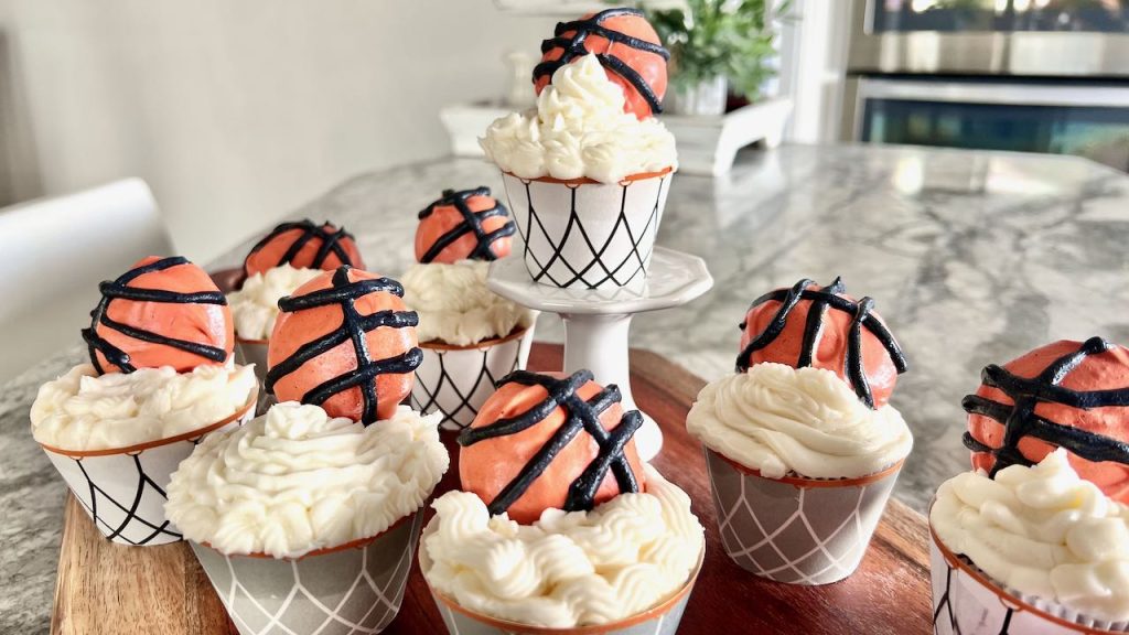 Basketball cupcake on a pedestal surrounded my more cupcakes