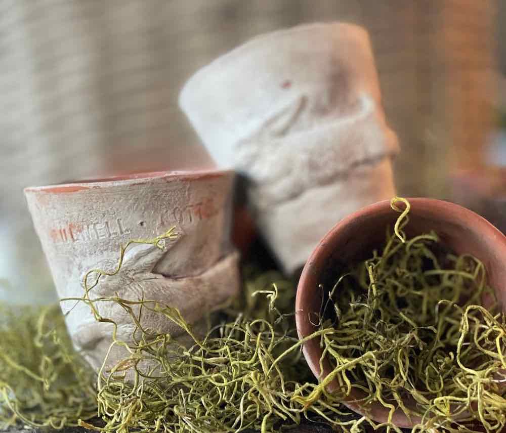 three vintage looking terracotta pots with clay bunnies