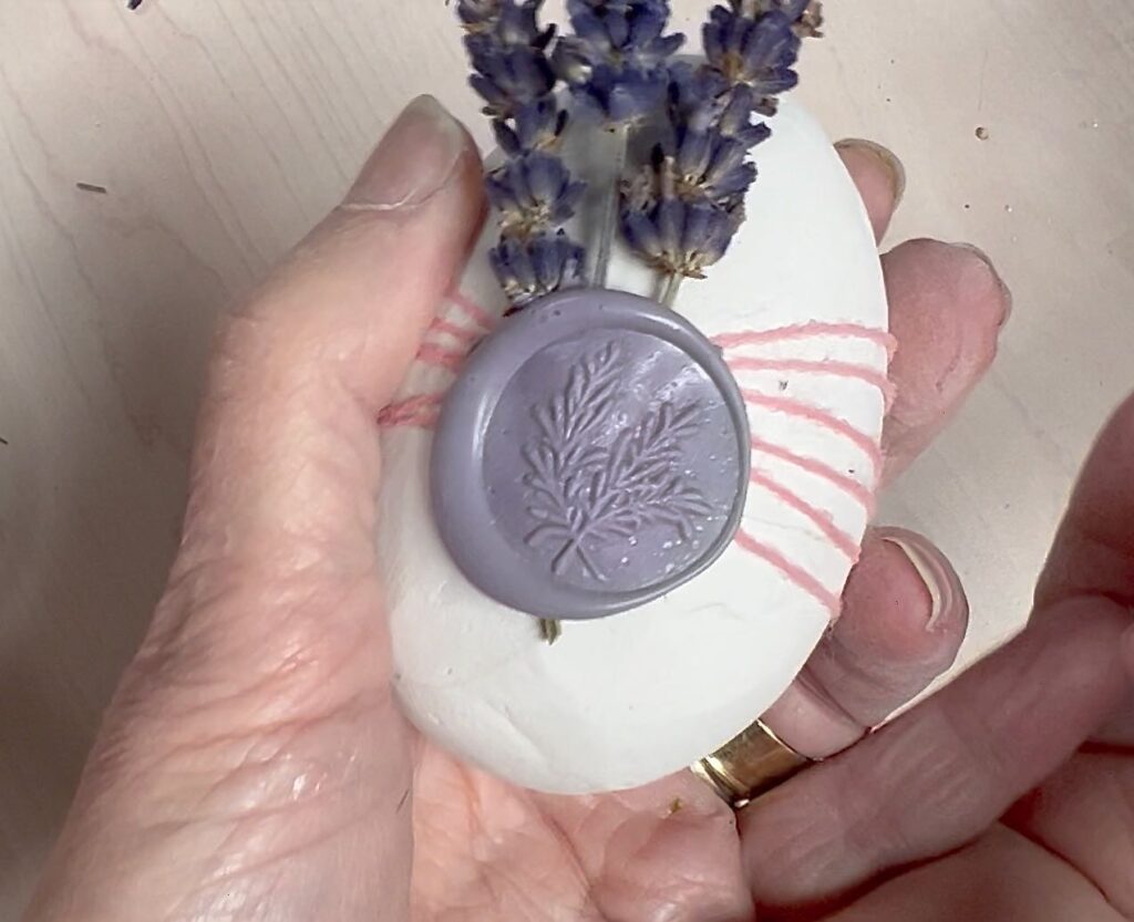 closeup of the wax seal on the egg on top of the flower stems and twine