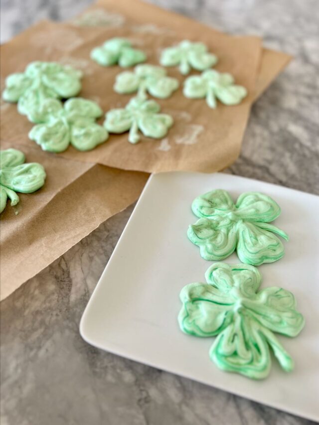 Title image of two shamrock cookies plated with more on parchment paper