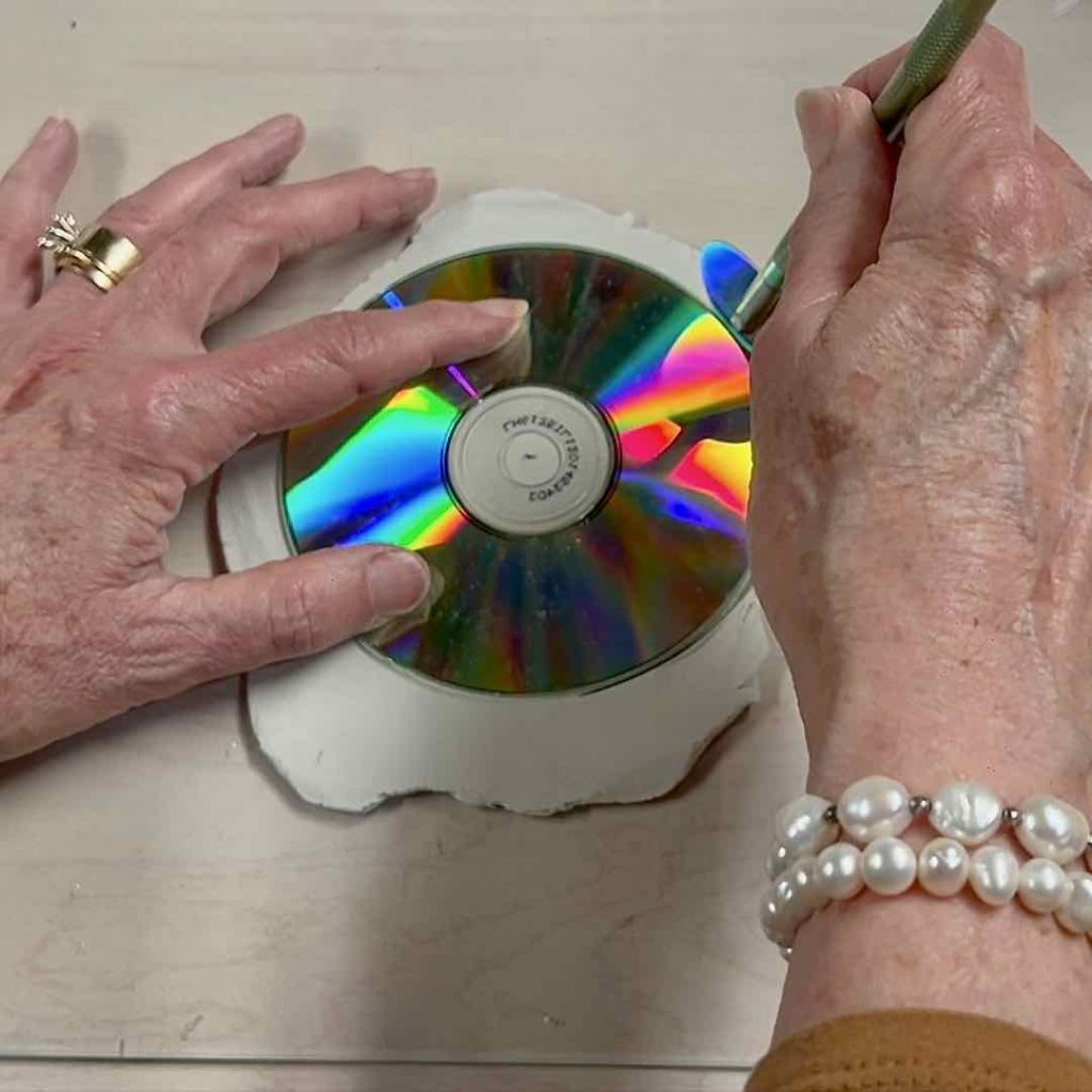 Closeup of cutting the clay using a CD as the guide