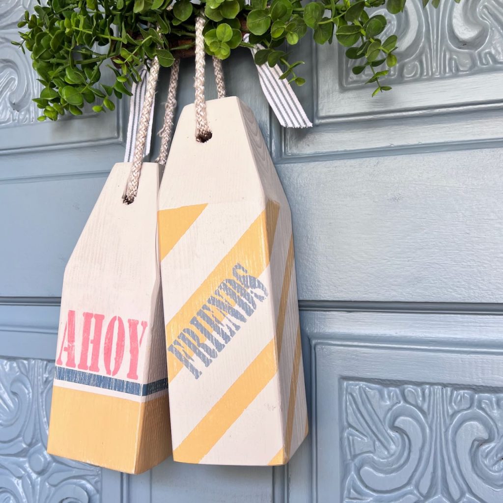 closeup of two buoys that say Ahoy Friends on a blue front