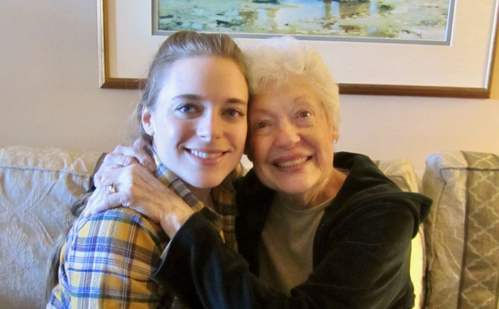 Smiling grandmother holding tight to her grown granddaughter