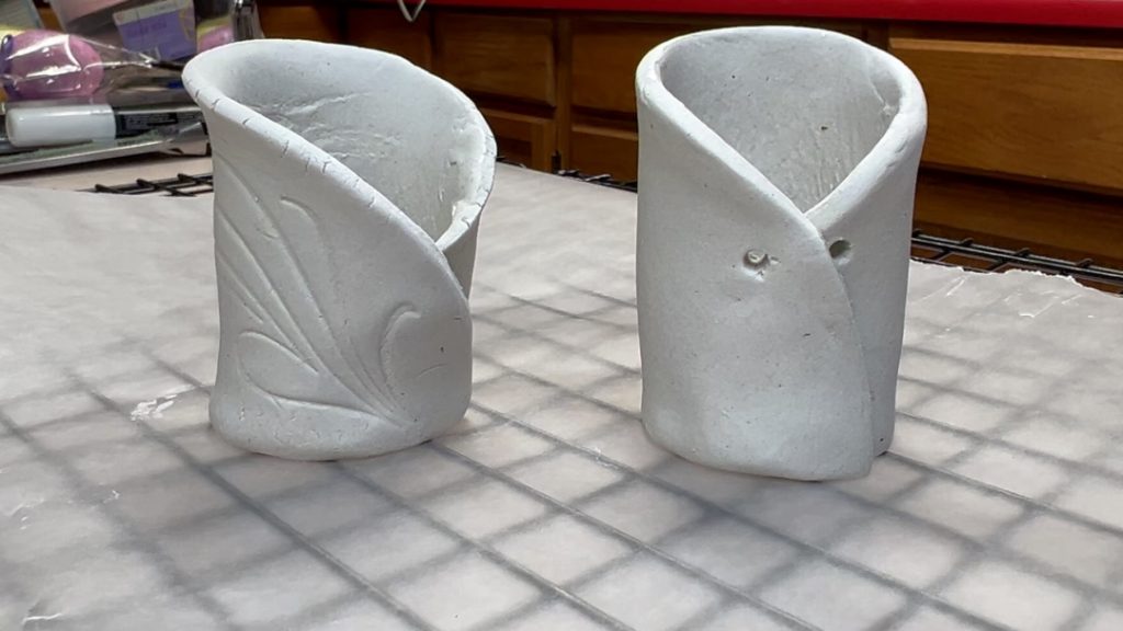 closeup of two pots drying on wax paper on a rack