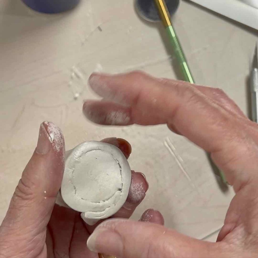 closeup of fingers smoothing the bottom of the pot