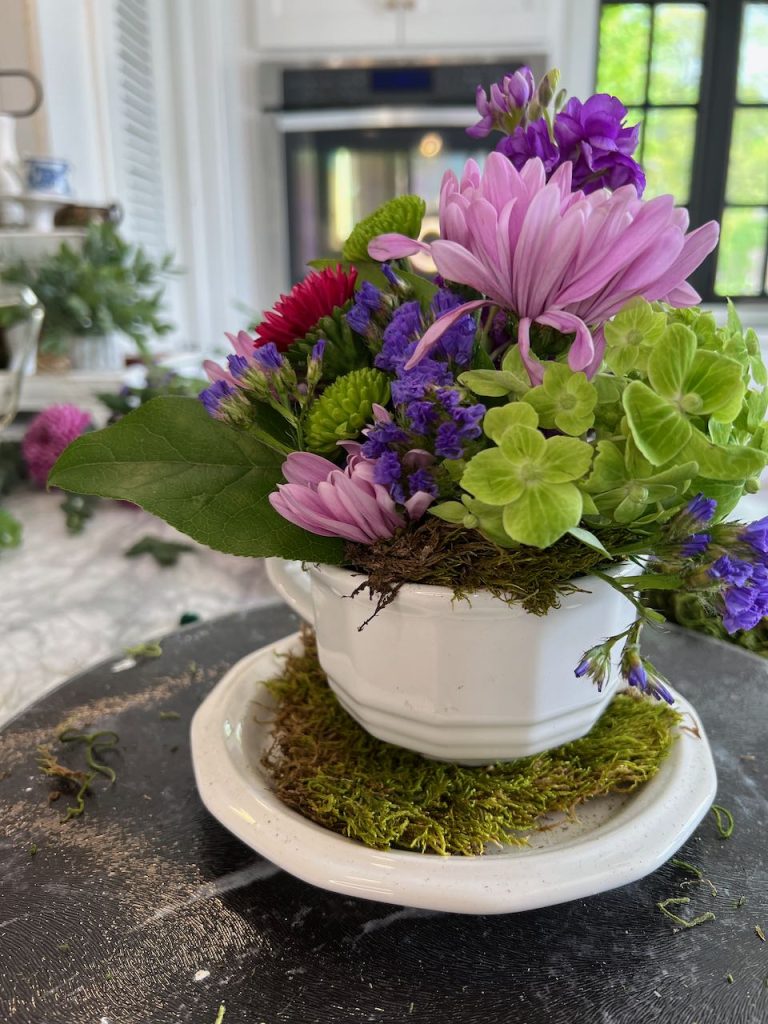 cup and saucer flower arrangement on a lazy susan in the kitchen