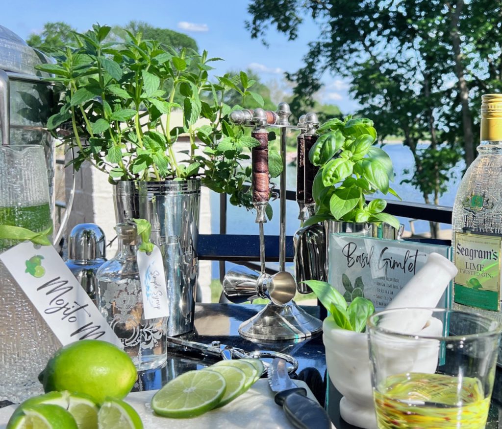 A cocktail making station of a vintage bar cart with a lake in the background