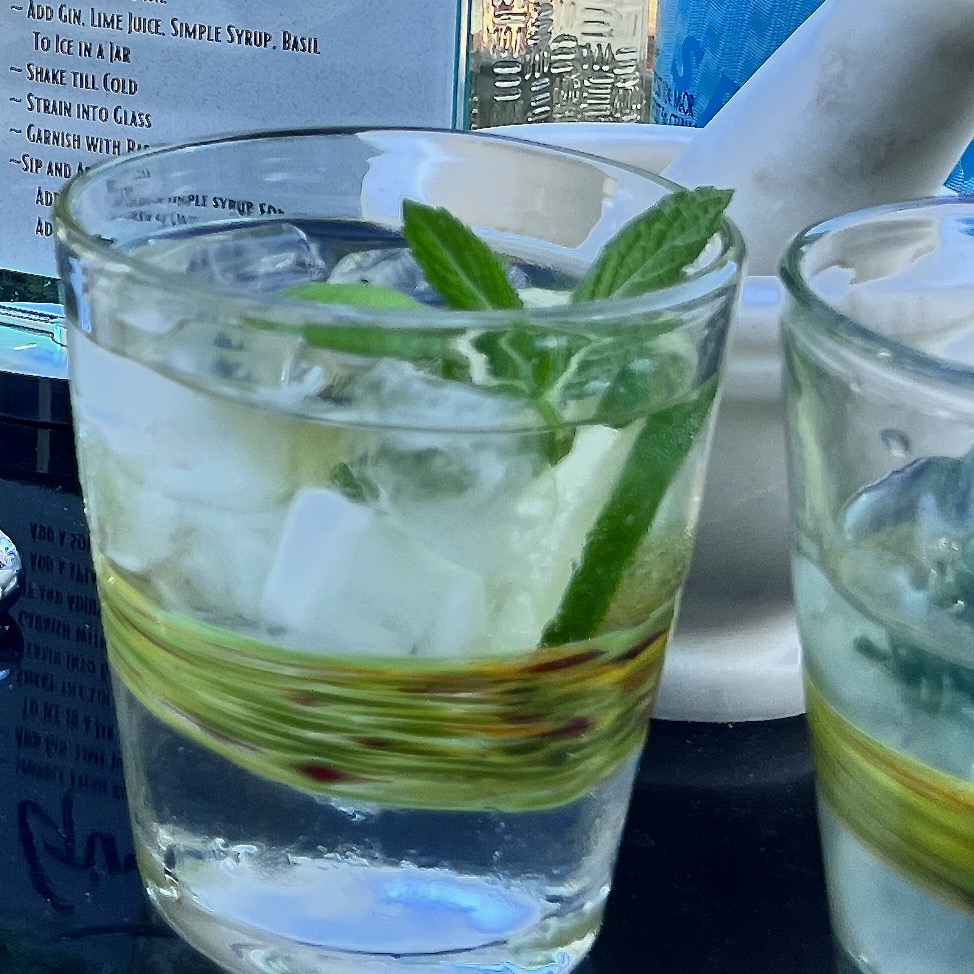 Closeup of mint leaves and a lime slice in a mojito cocktail