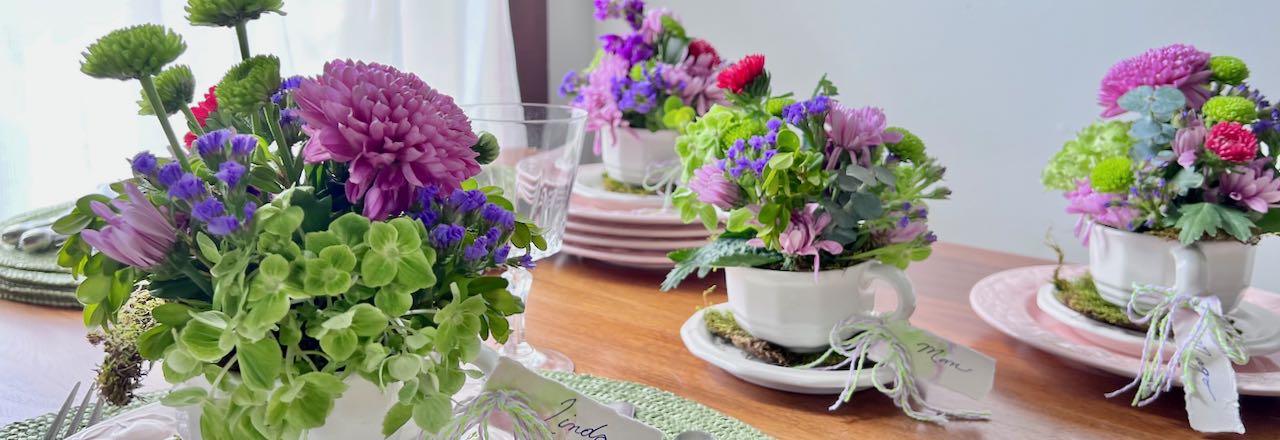 Cup and saucer flower arrangements on a dinner table