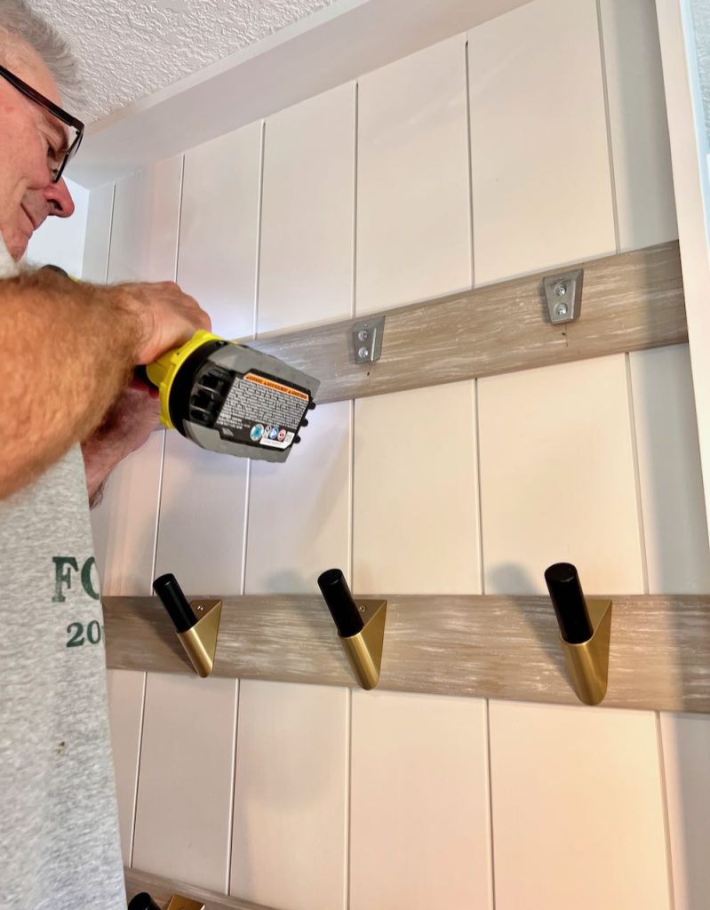 a man is attaching the hooks to the board