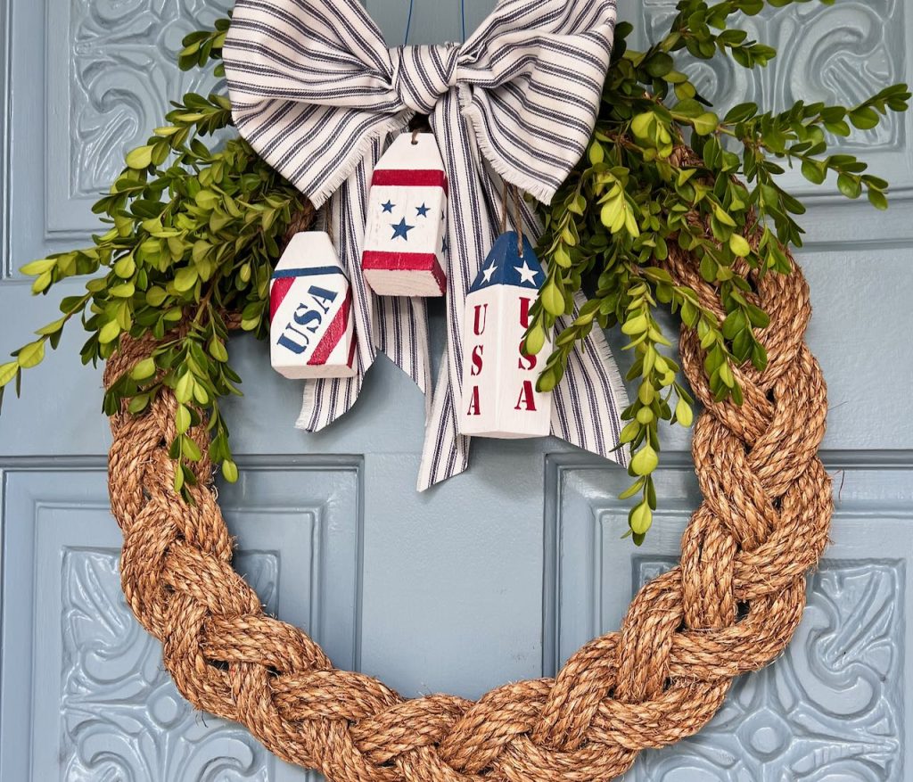 braided rope wreath embellished with large ticking ribbon and three mini wooden buoys