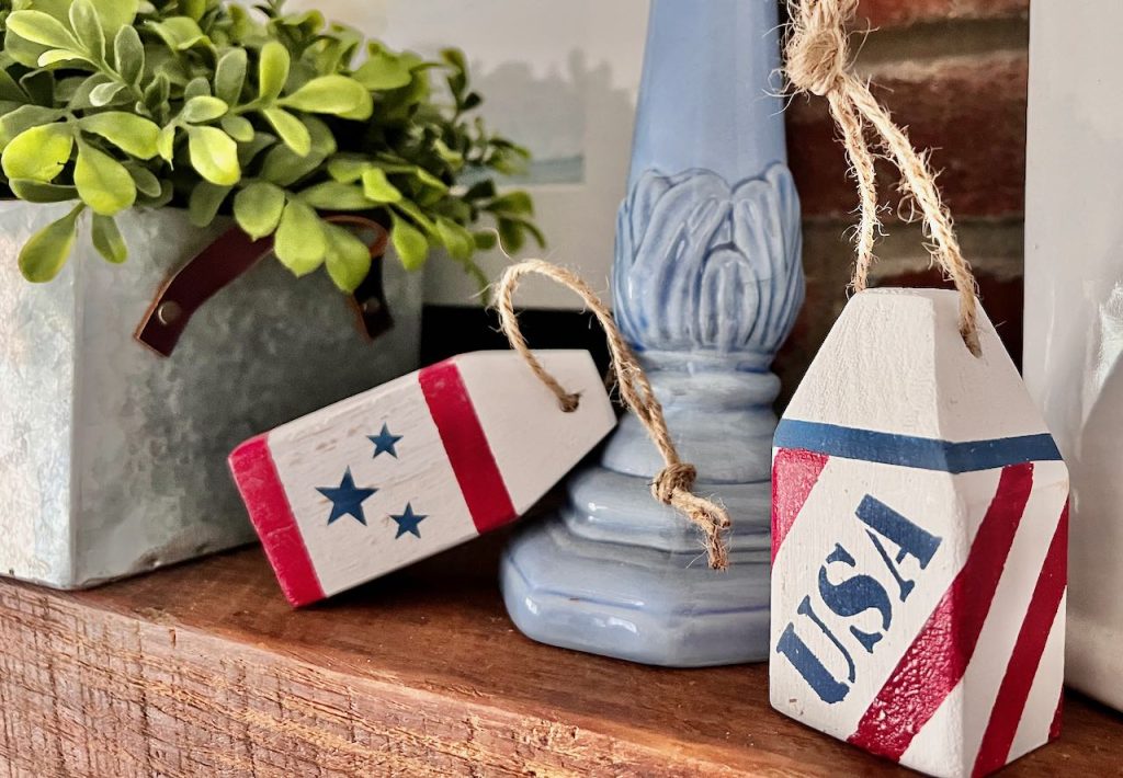 Two mini wooden buoys decorated for 4th of July on a mantel