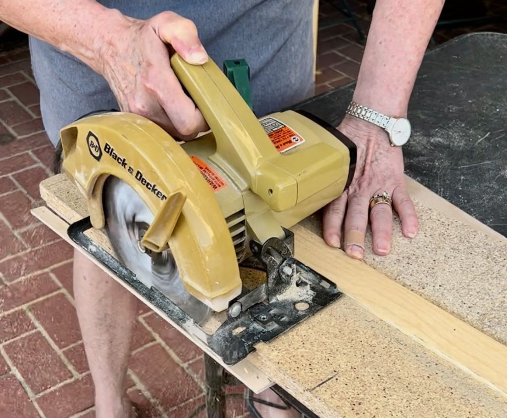 woman cutting a long board with a circular saw