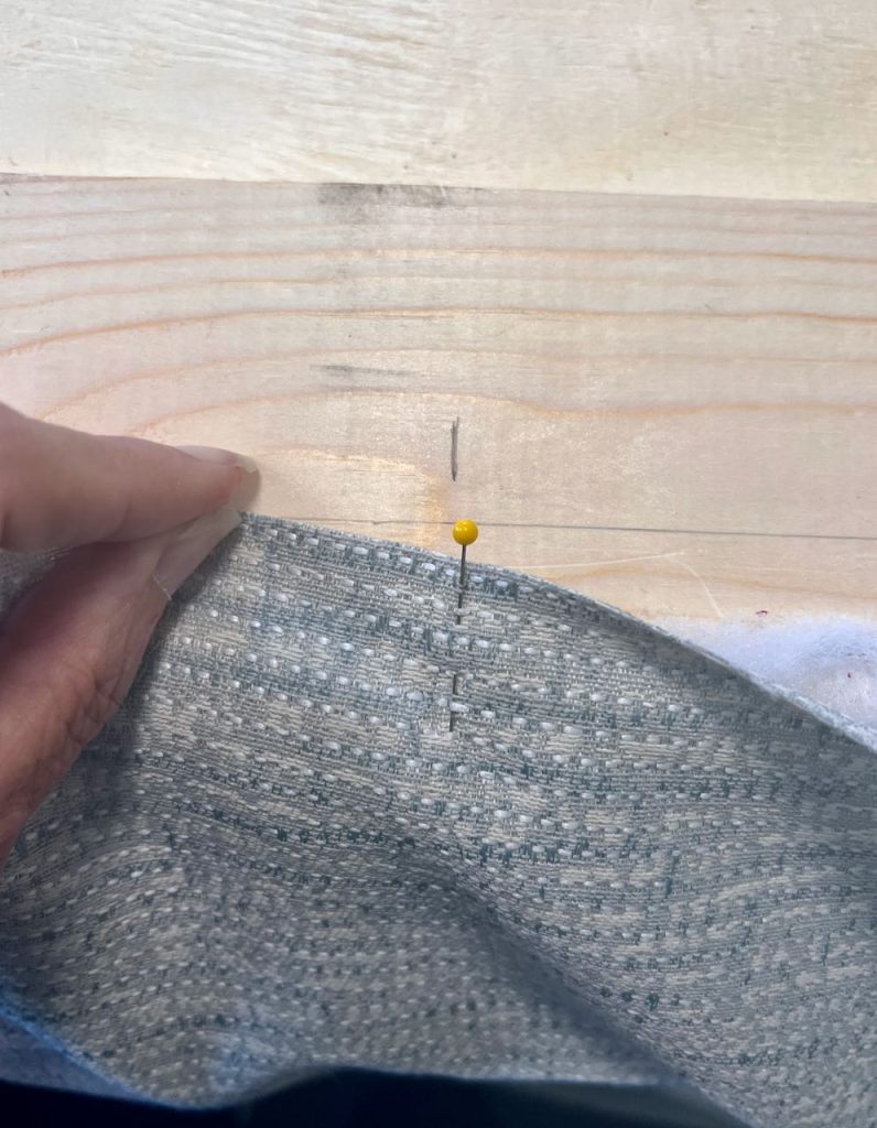 a pin in the center of the fabric matches up with a mark at the center of the wood