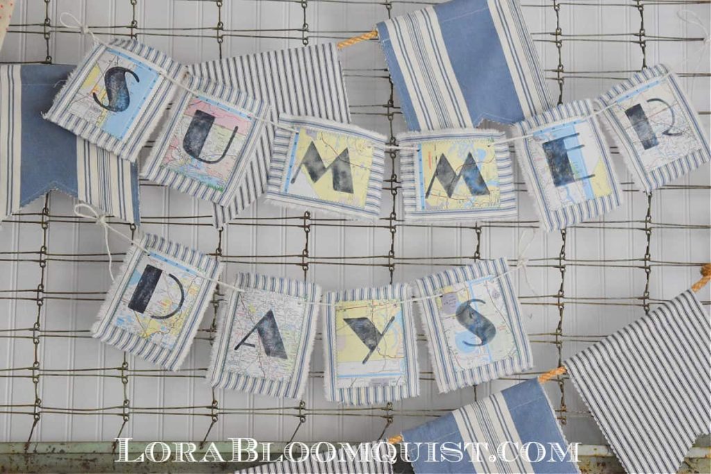 Fabric Bunting with letters stenciled on maps glued on ticking fabric tht reads "Summer Days"