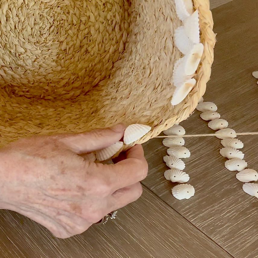 super closeup of woman's thumb holding shell along the top of a basket