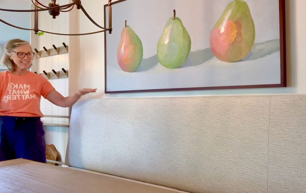 smiling woman standing next to the finished banquette backrest and cushion