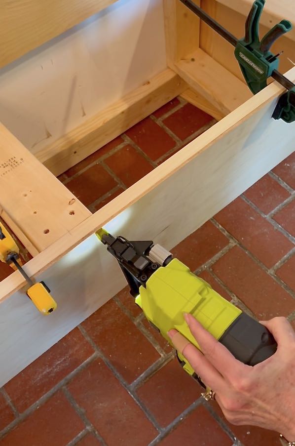 woman brad nailing plywood veneer face to front of banquette