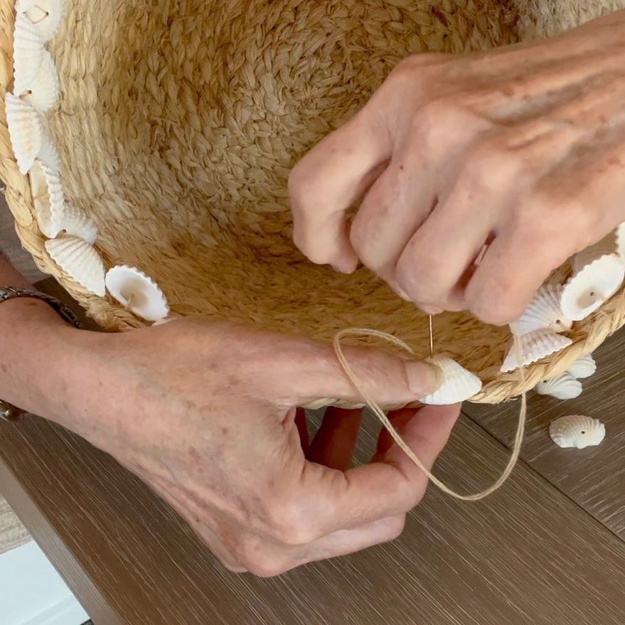 woman's hand is shown pushing the needle back down through the shell