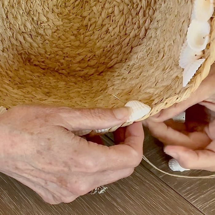 super closeup of a needle coming up through a basket on one side of a seashell