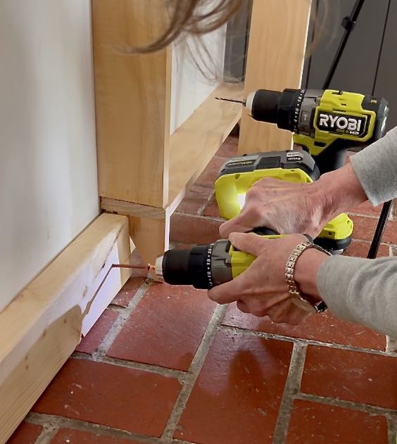 woman drilling a 2 x 4 into the wall