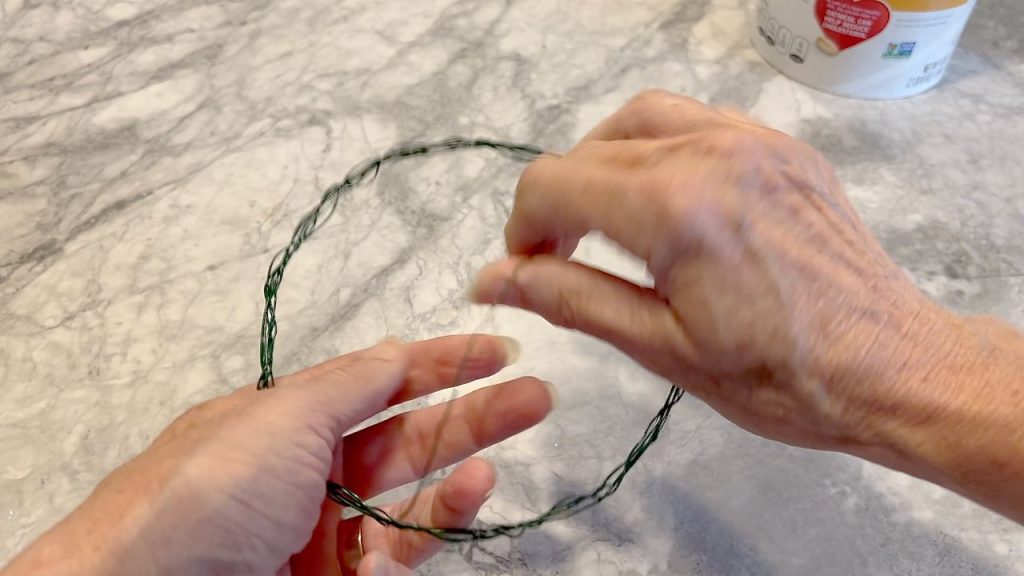 woman's hands showing wrapping wire around the wreath form