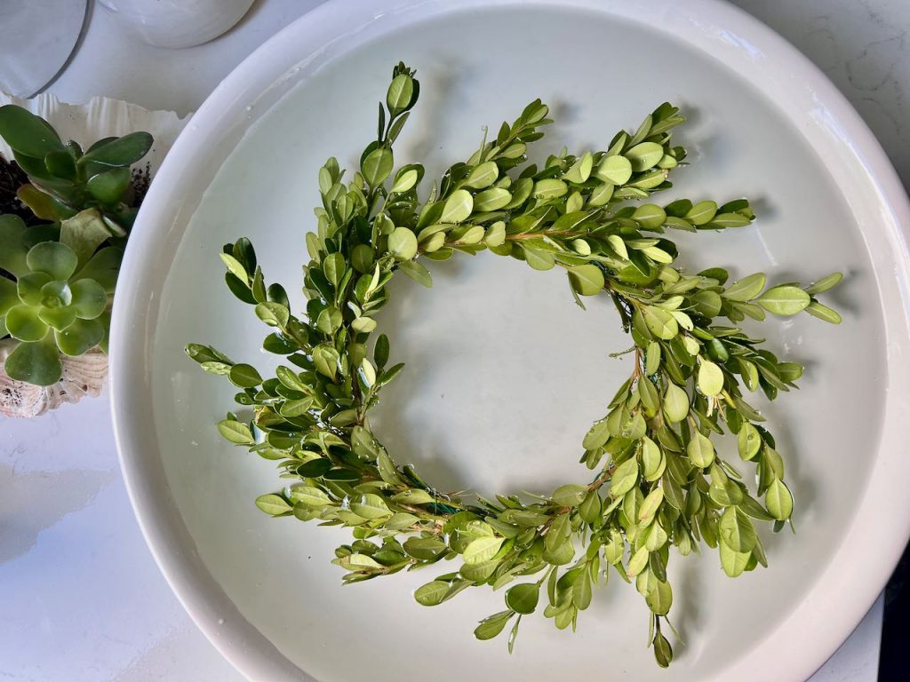 Finished wreath is soaking in a bowl of water on the kitchen counter