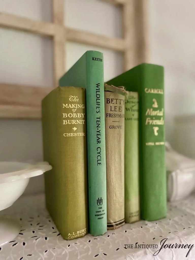 set of 5 vintage books all shades of green are standing together