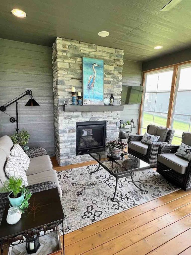 interior of a screened porch with a stone fireplace