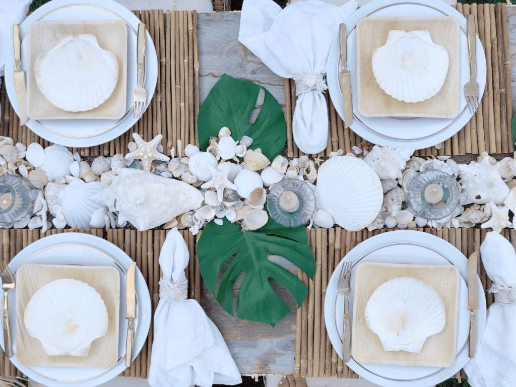 overhead image of shells on bamboo plates with sea shells as a runner.