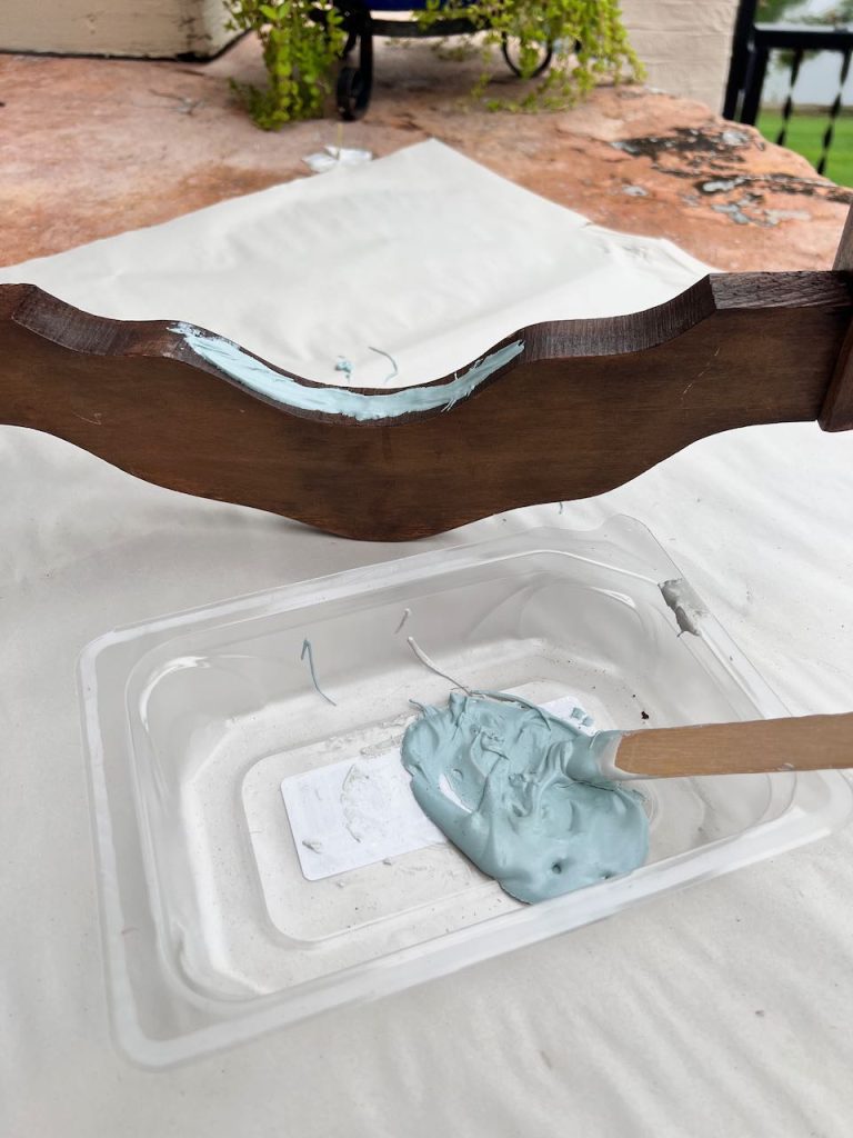 closeup of Bondo filler mixed in a plastic container and filling the groove of the chair back