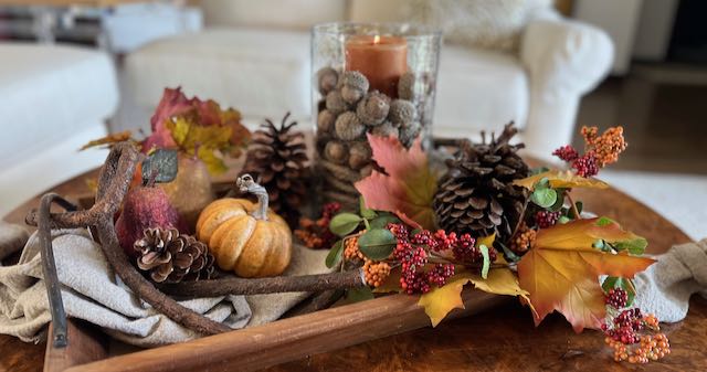 closeup of Candle hurricane surrounded with hFall leaves, berries and pumpkins